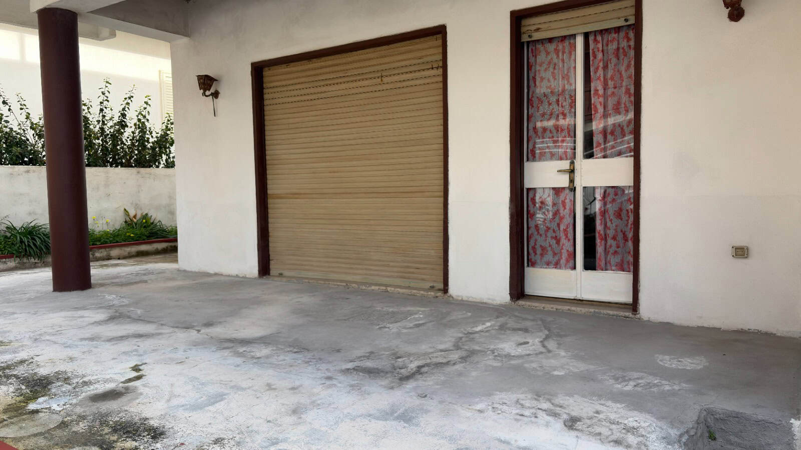 Porte e finestre di una casa con garage e ingresso principale, vista dall'esterno in un ambiente residenziale.