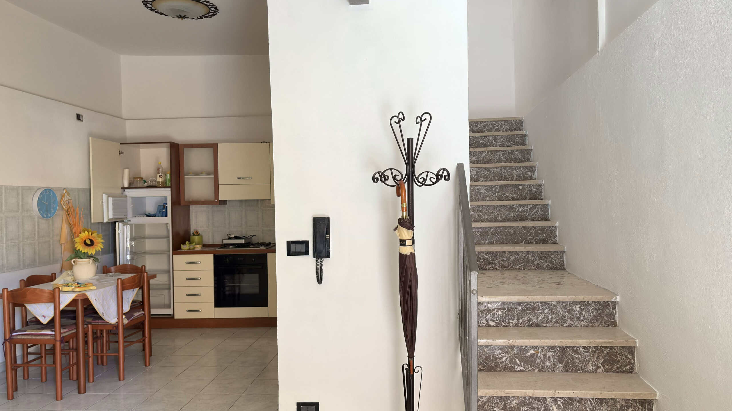 Elegante ingresso con scala in pietra e pareti bianche, ideale per appartamenti moderni e accoglienti.