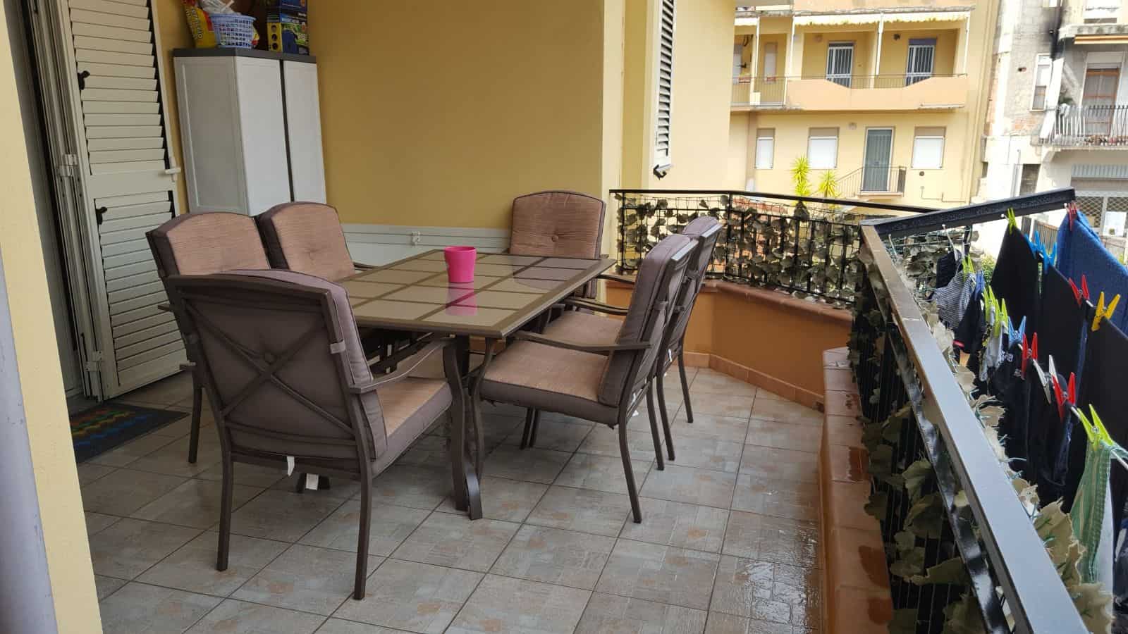 Ampia terrazza con tavolo e sedie in esterno, ideale per pranzi e relax, con vista su edifici residenziali, ambiente luminoso e accogliente, perfetta per vivere momenti all'aperto.