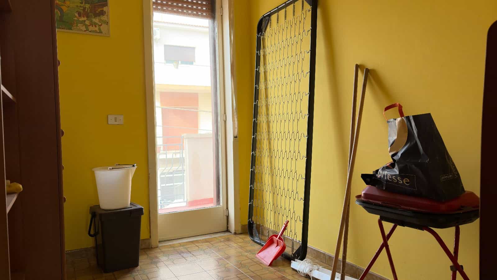 Ampia porta finestra che permette l'ingresso di luce naturale in un ambiente domestico.