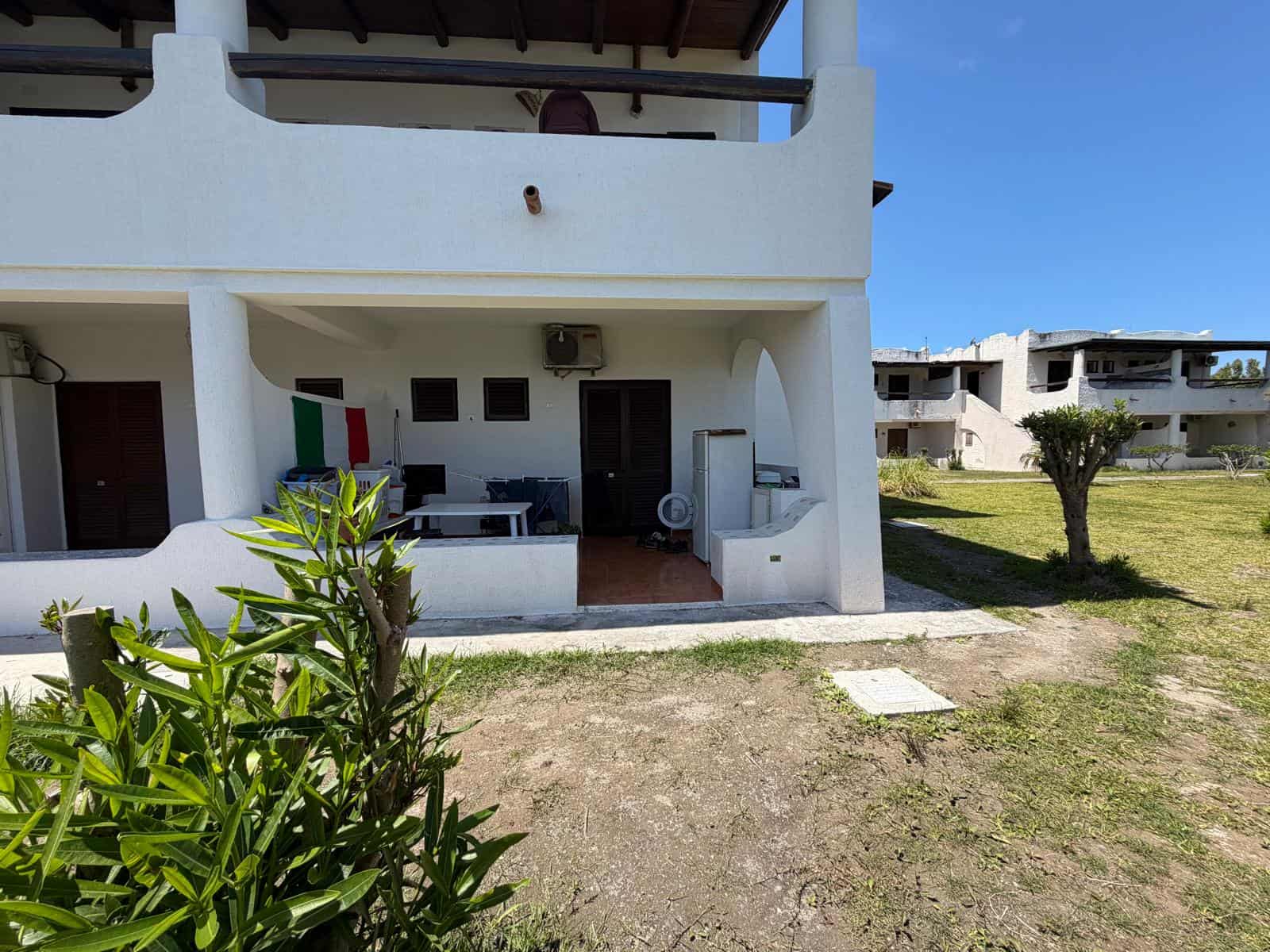 Aggiungi una terrazza esterna di una casa vacanze con vista sul giardino e sull'area circostante, ideale per relax e convivialità.
