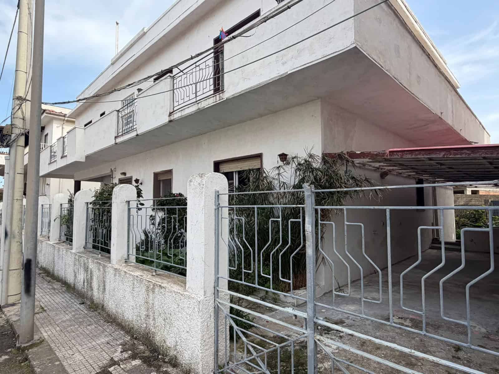 Casa indipendente con giardino e garage, struttura moderna in zona residenziale, facciata bianca e balconi, ideale per famiglie in cerca di comfort e spazio.