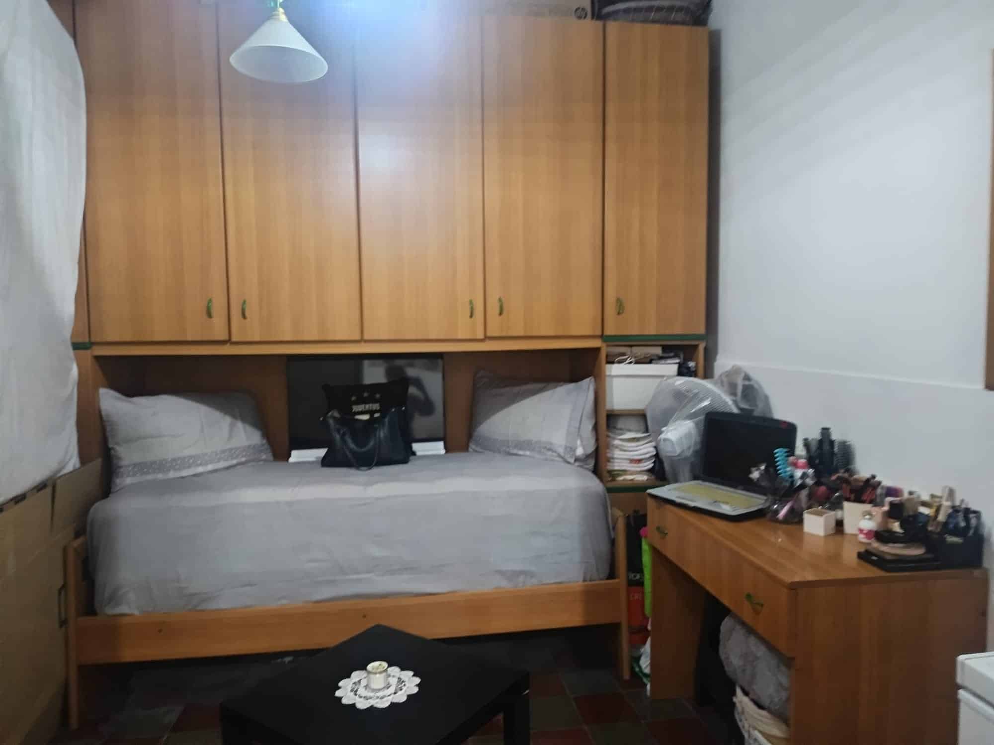 Letto singolo con armadio a muro in camera da letto, arredamento funzionale e pratico, spazio ottimizzato per il riposo e l'organizzazione degli abiti. Ideale per ambienti moderni e piccoli spazi abit.