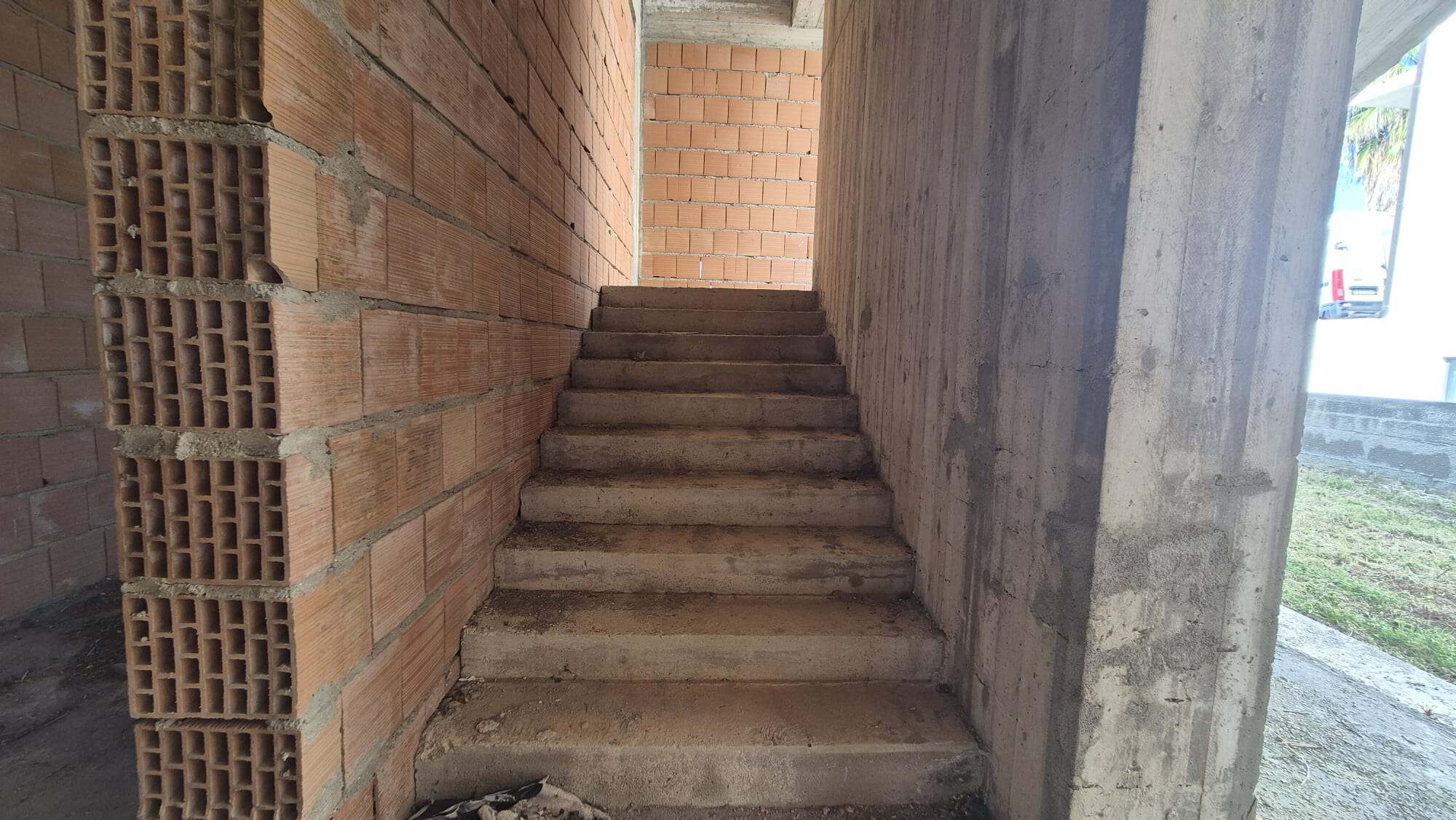 Piantina di una scala in costruzione con pareti in mattoni e cemento, in fase di realizzazione di un edificio residenziale o commerciale.