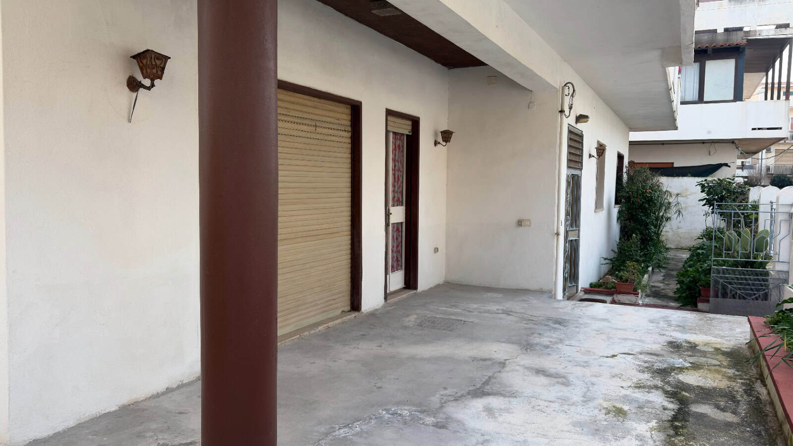 Ampio spazio esterno di un'abitazione con area parcheggio e giardino, ideale per residenze in zona urbana tranquilla, con accesso diretto alla casa e ambienti esterni ben curati.