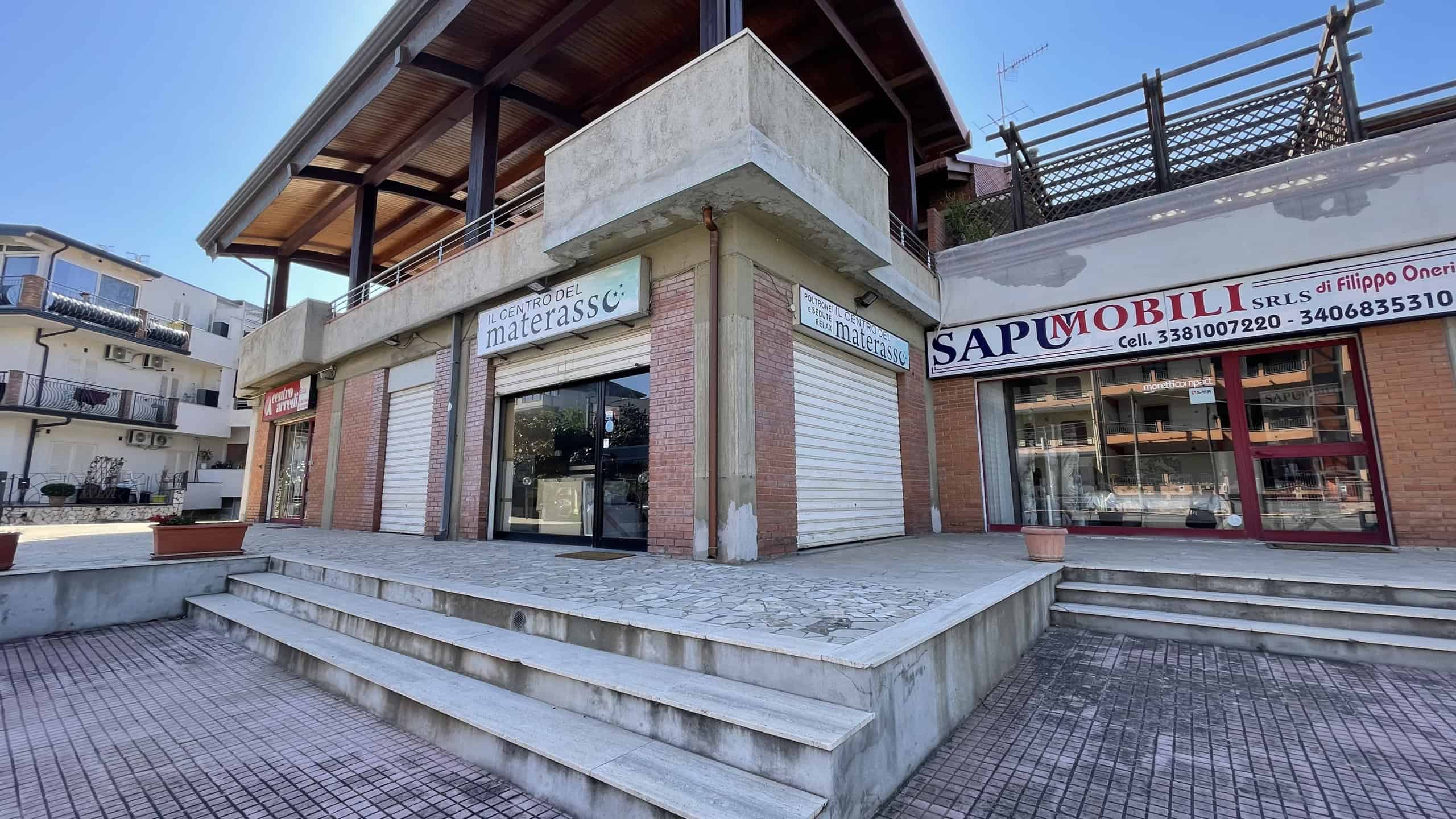 Ampio negozio commerciale con vetrine su strada, ingresso con scale e spazio espositivo in centro città, ideale per attività commerciali e uffici.