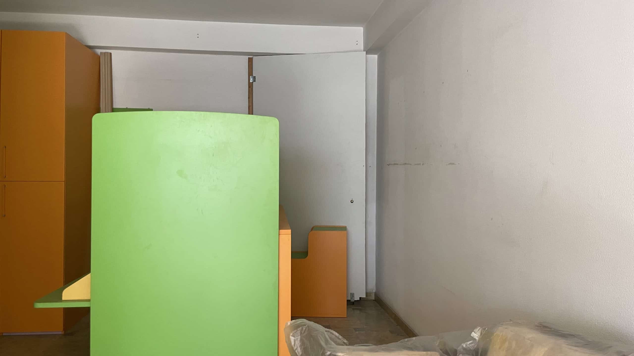 Lavagna verde in un ufficio moderno con pareti bianche e arredi colorati, ideale per brainstorming e riunioni creative.