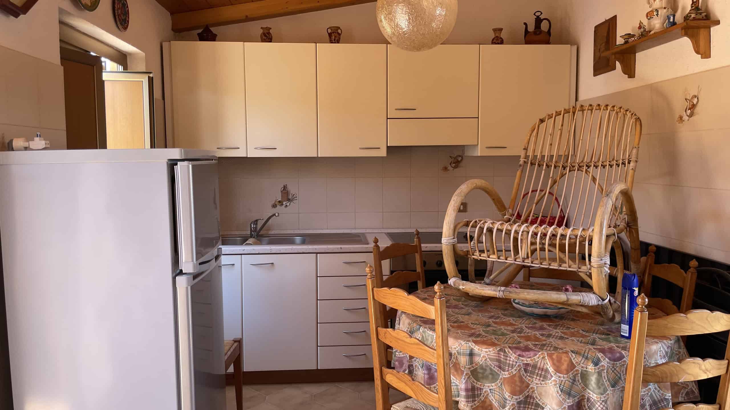 Elegante cucina con mobili bianchi e dettagli decorativi, ideale per vivere un'esperienza culinaria confortevole e funzionale. Perfetta per case moderne e accoglienti.