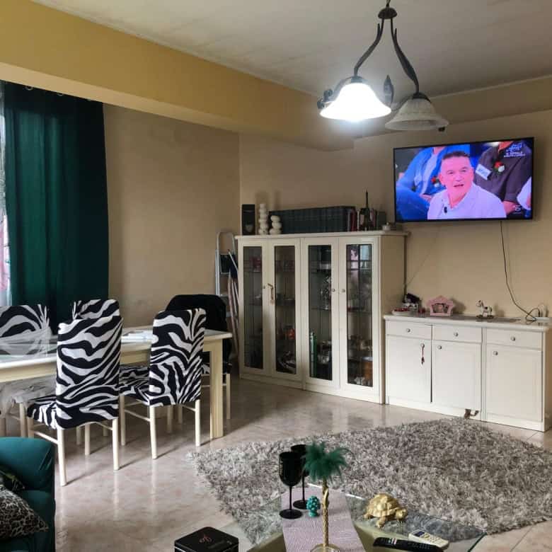 Sedia da pranzo con sedie zebra print in soggiorno luminoso con TV e arredi moderni.