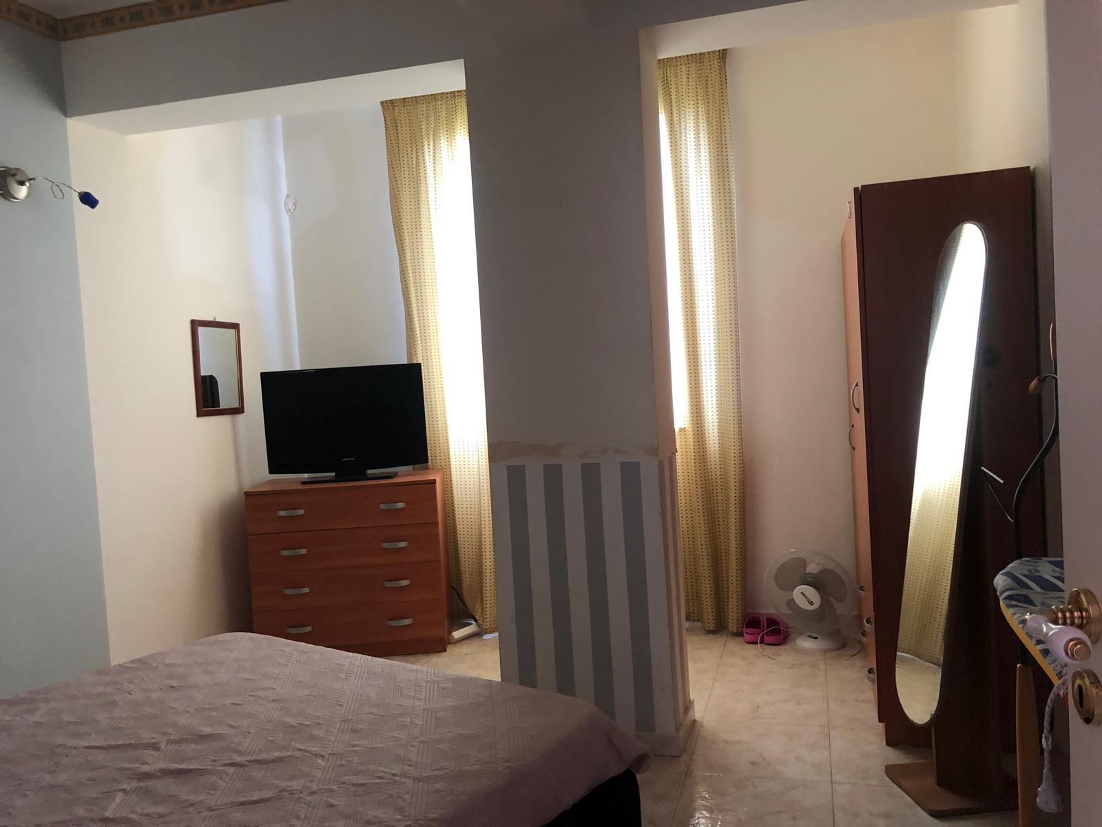 Ampia camera da letto con finestra luminosa, armadio e televisore, ambiente accogliente e ben illuminato, ideale per soggiorni confortevoli e rilassanti.