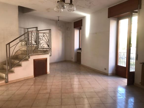 Ampia zona giorno con pavimenti in ceramica, pareti bianche e grandi finestre che lasciano entrare molta luce naturale, ideale per living luminosi e accoglienti.