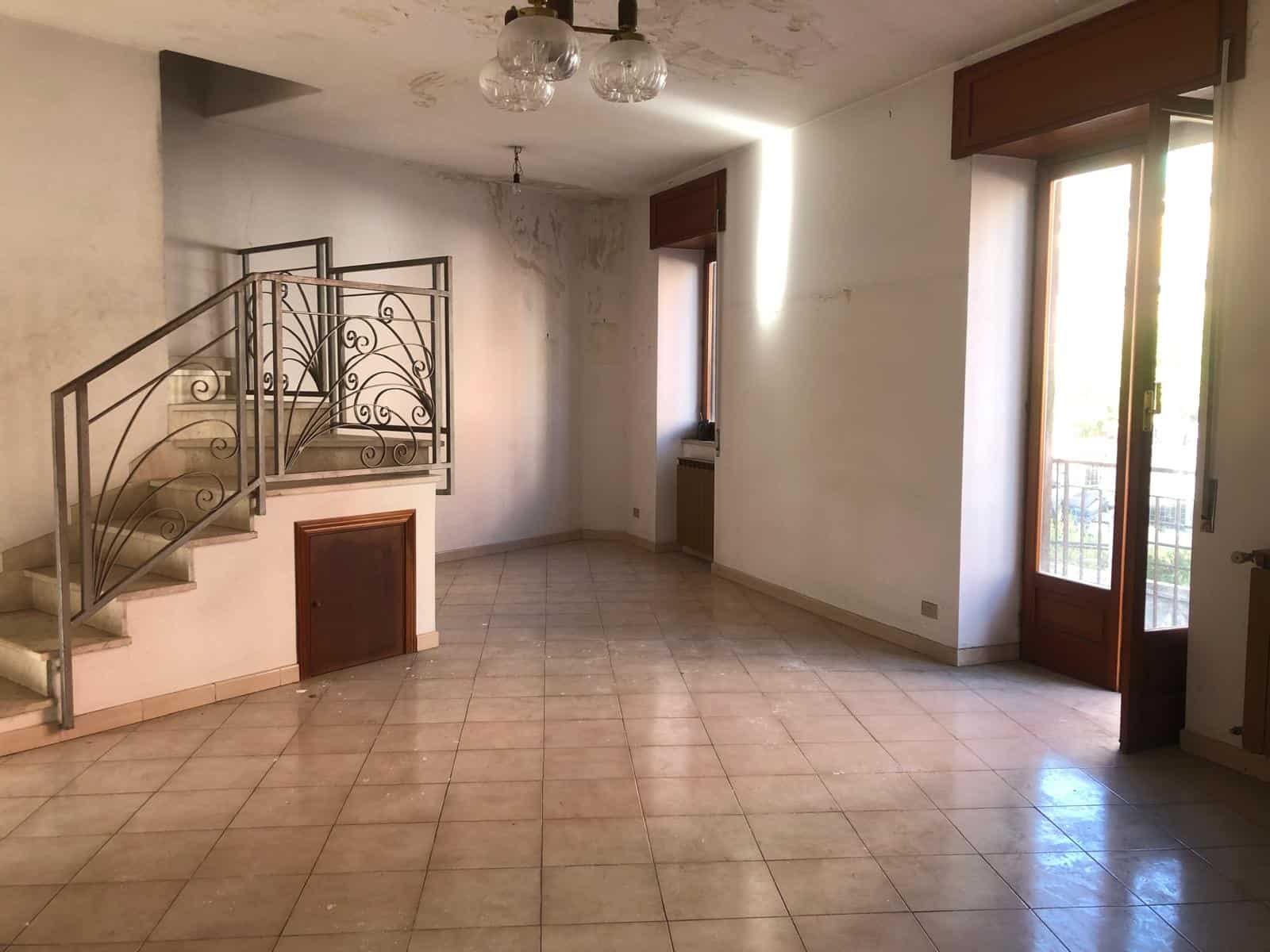 Ampia zona giorno con pavimenti in ceramica, pareti bianche e grandi finestre che lasciano entrare molta luce naturale, ideale per living luminosi e accoglienti.