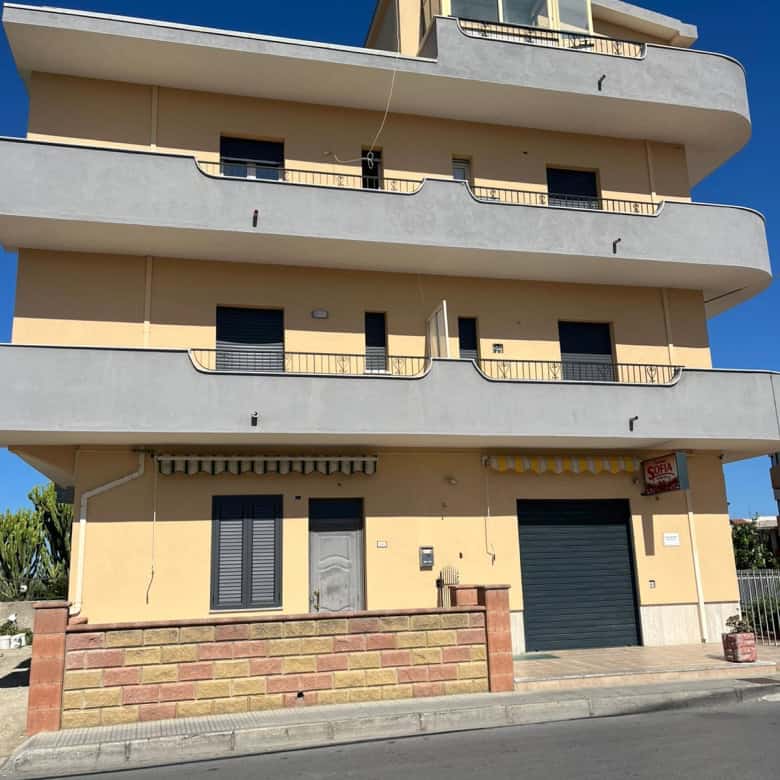 Vasta palazzina residenziale moderna con tre piani, balconi ampi e finestre grandi, situata in zona urbana soleggiata, ideale per famiglie e investimenti immobiliari in Italia.