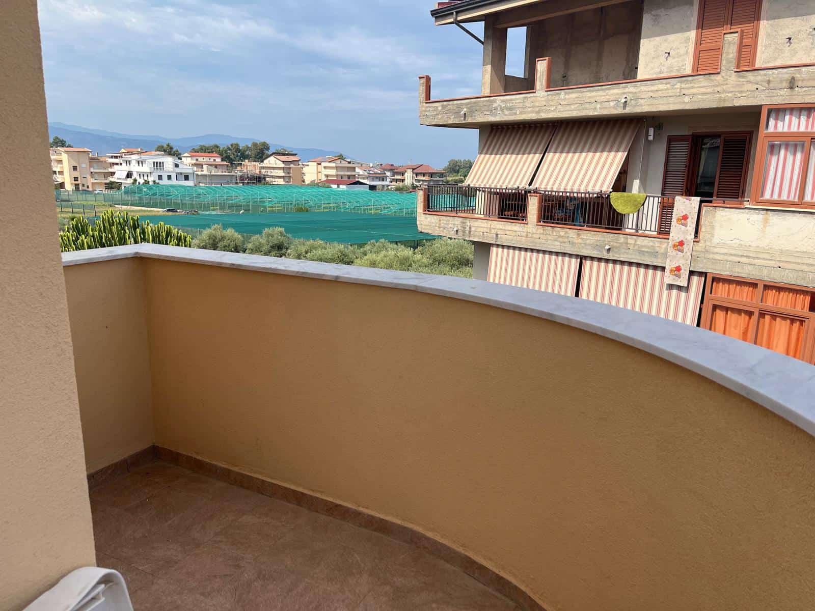Balcone panoramico con vista su quartiere residenziale e natura, ideale per relax e momenti all'aperto in un ambiente tranquillo e luminoso.
