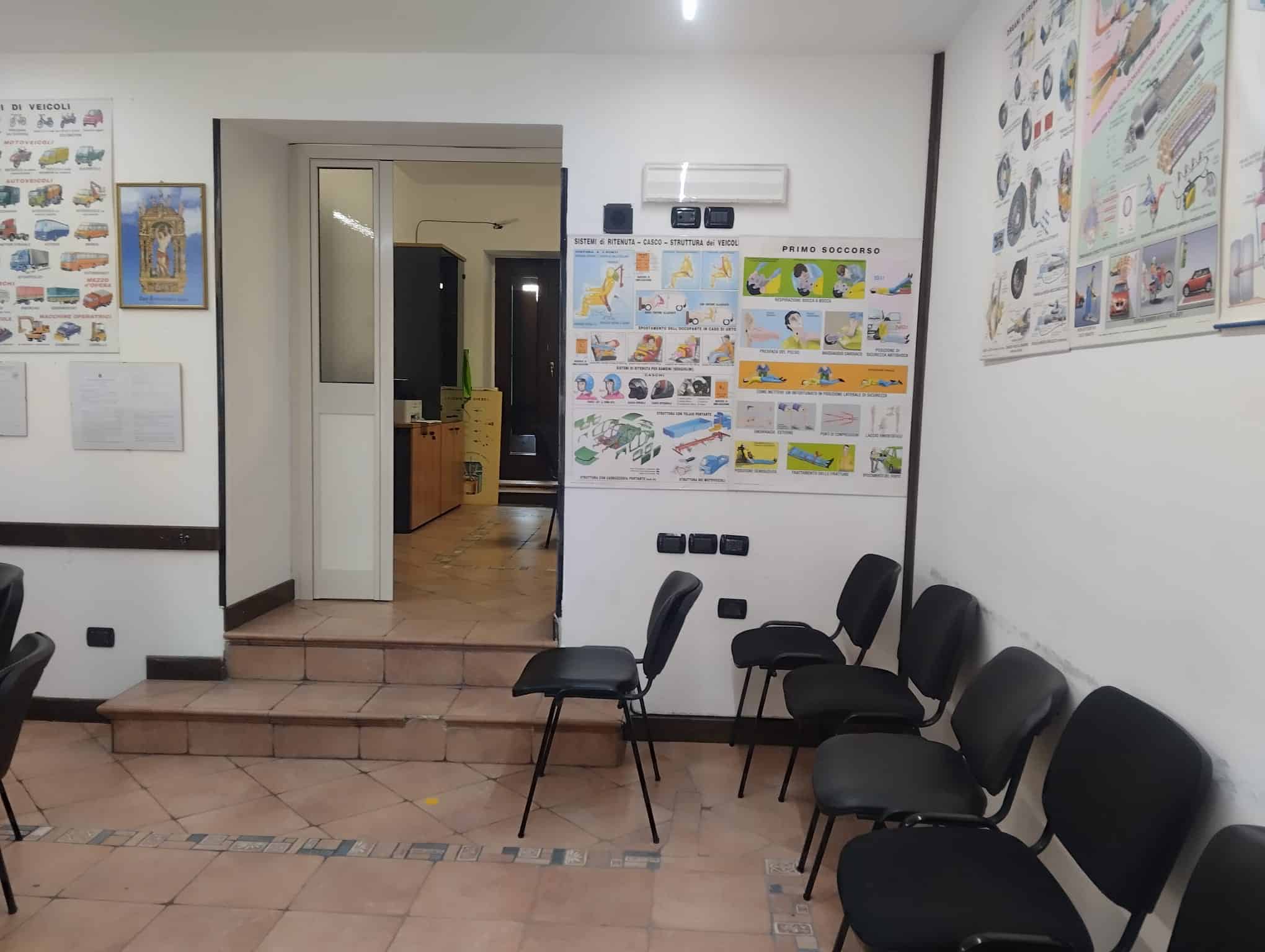 Sala d'attesa con sedie nere e poster educativi sulle procedure di sicurezza e igiene, ambiente luminoso e accogliente, ideale per studi medici o uffici pubblici in Italia.