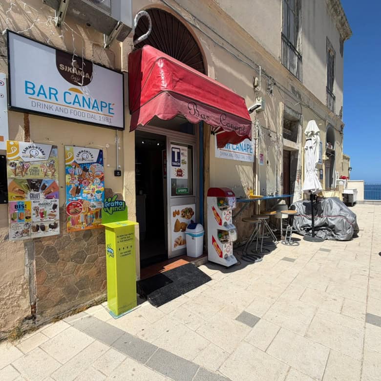 Bar Canape, locale sulla passeggiata con tavoli all'aperto, offre drink e snack in un ambiente accogliente con vista mare, ideale per relax e socializzazione durante le giornate estive.