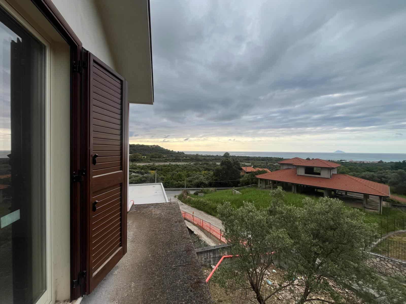 VISTA PANORAMICA DALLA TERRAZZA DI UNA CASA CON FINESTRINI IN LEGNO, PANORAMA SULLE COLLINE E IL MARE, Cielo nuvoloso, ambiente tranquillo e naturale, ideale per relax e momenti di pace all'aperto.