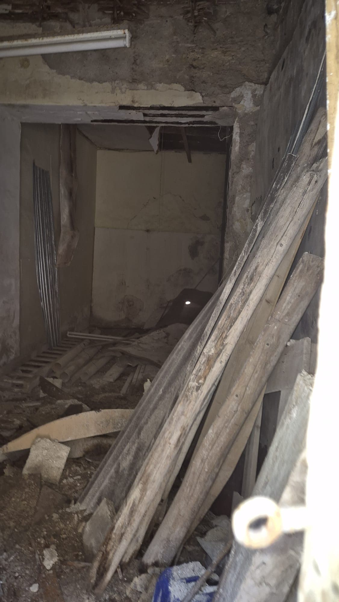 Ripresa di un cantiere edile con materiali da costruzione e attrezzature in un ambiente interno in fase di ristrutturazione.