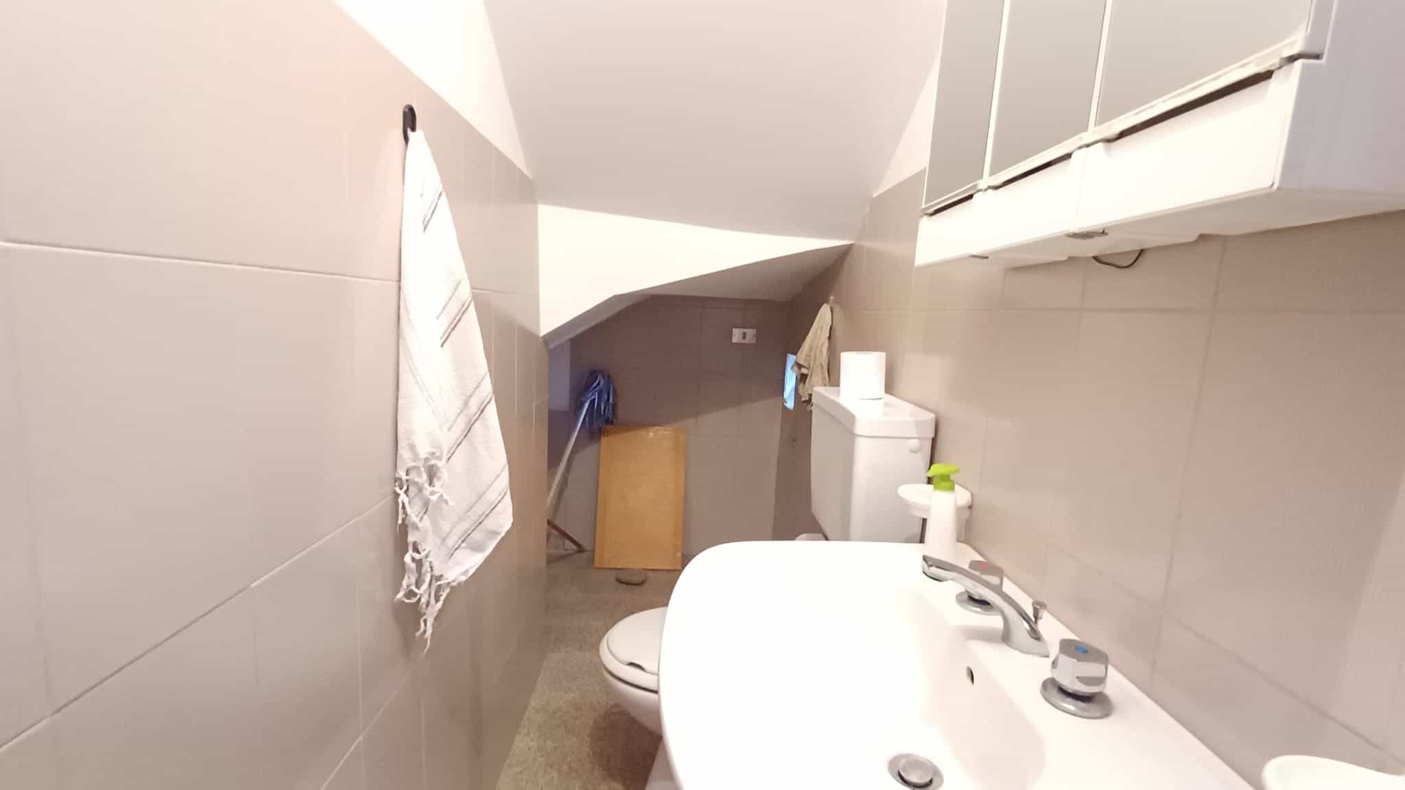 Spazzolino e prodotti per l'igiene personale sul lavandino in un bagno moderno e ben illuminato.