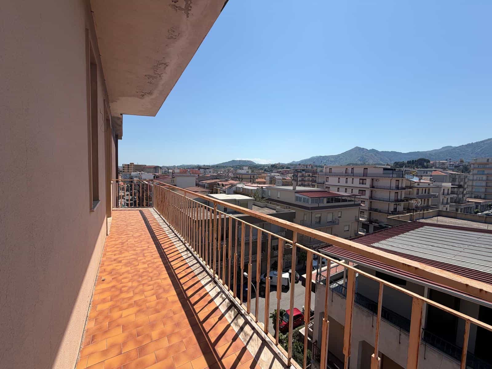 Ampio balcone con vista panoramica sulla città e sulle montagne, ideale per relax e momenti all'aperto.