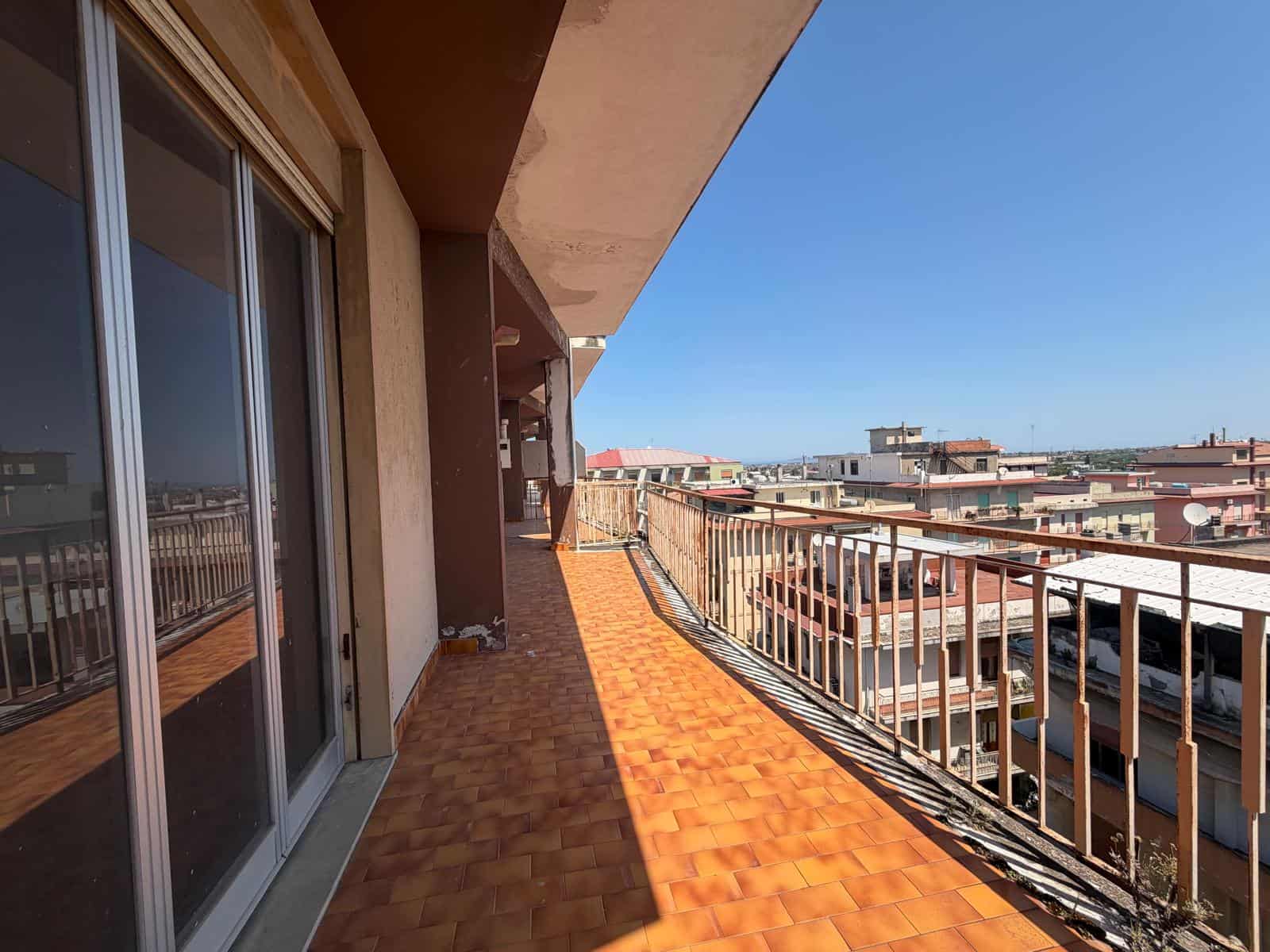 Balcone spazioso con vista urbana, pavimentato in terracotta, ideale per relax e socializzazione, in un edificio residenziale ben mantenuto nel centro città.