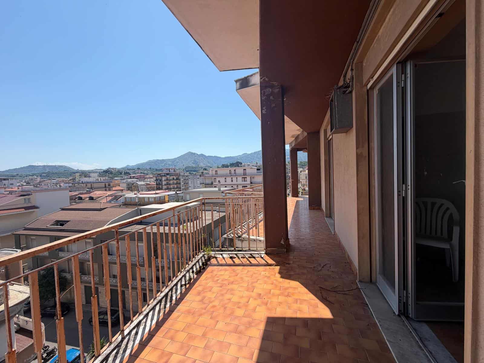 Ampio balcone con vista panoramica sulla città e sulle montagne, ideale per relax e momenti all'aperto, in un appartamento NextCasa in Italia.