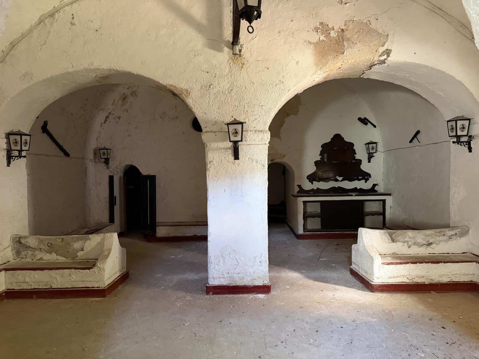 Antico ambiente in pietra con archi e arredi tradizionali, ideale per valorizzare le proprietà storiche e culturali in Italia.