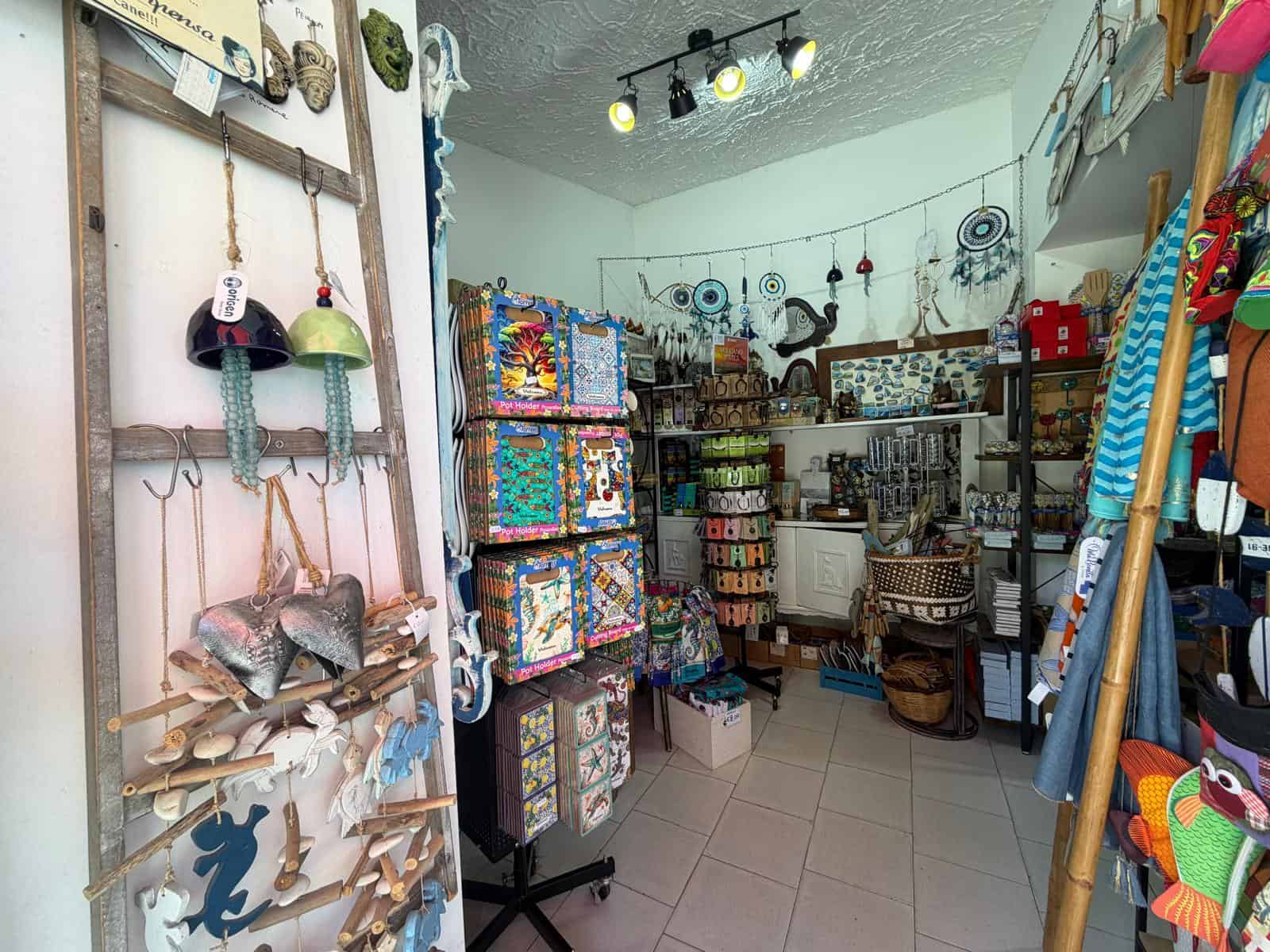 Le immagini mostrano un negozio di artigianato e decorazioni con vari oggetti colorati e fatti a mano, tra cui tessuti, decorazioni in legno e accessori per la casa, ideale per chi cerca prodotti unic.