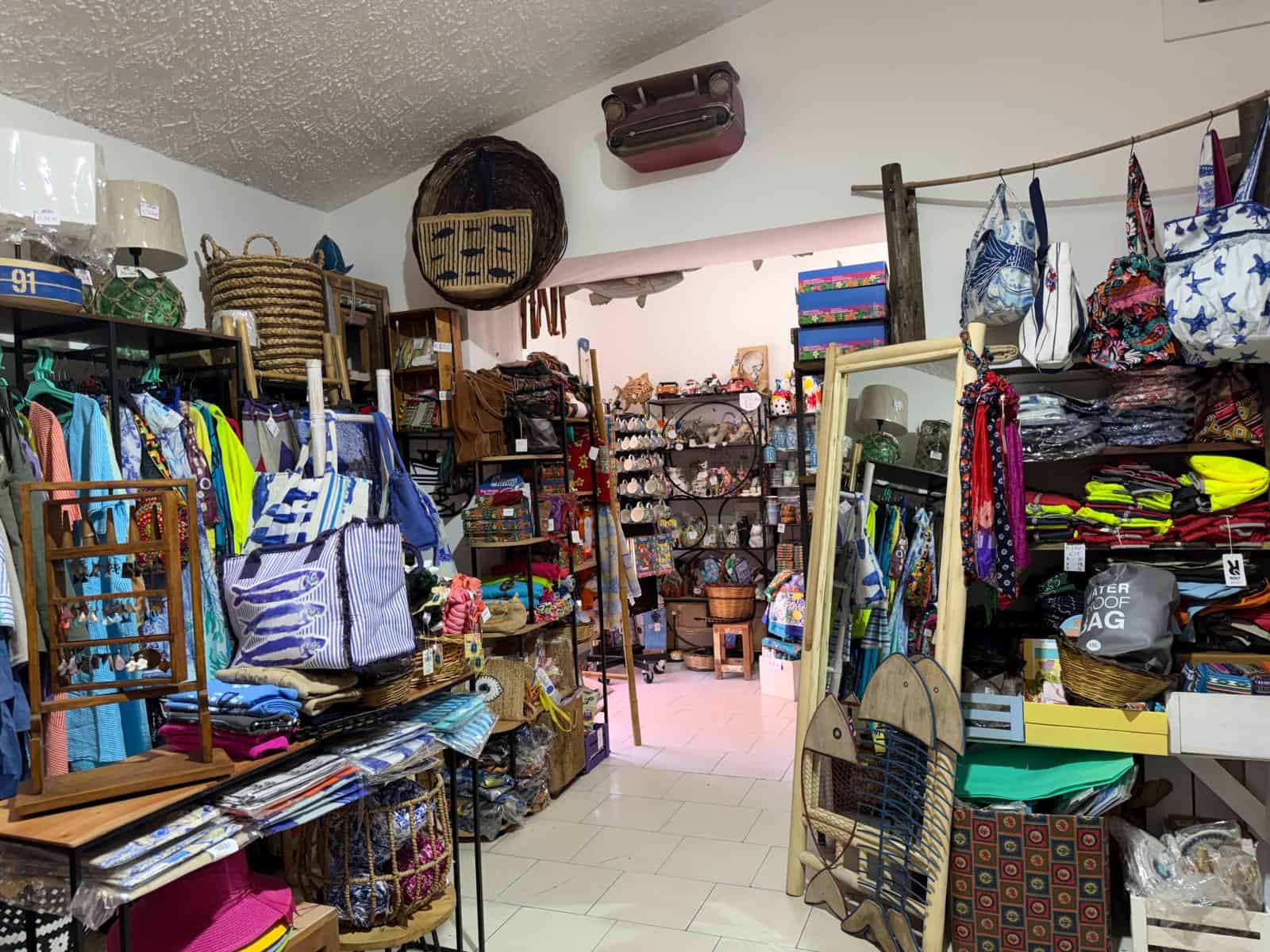 Negozio di articoli da regalo e accessori moda con vasta selezione di borse, abbigliamento e oggetti decorativi in un ambiente accogliente e ben organizzato.