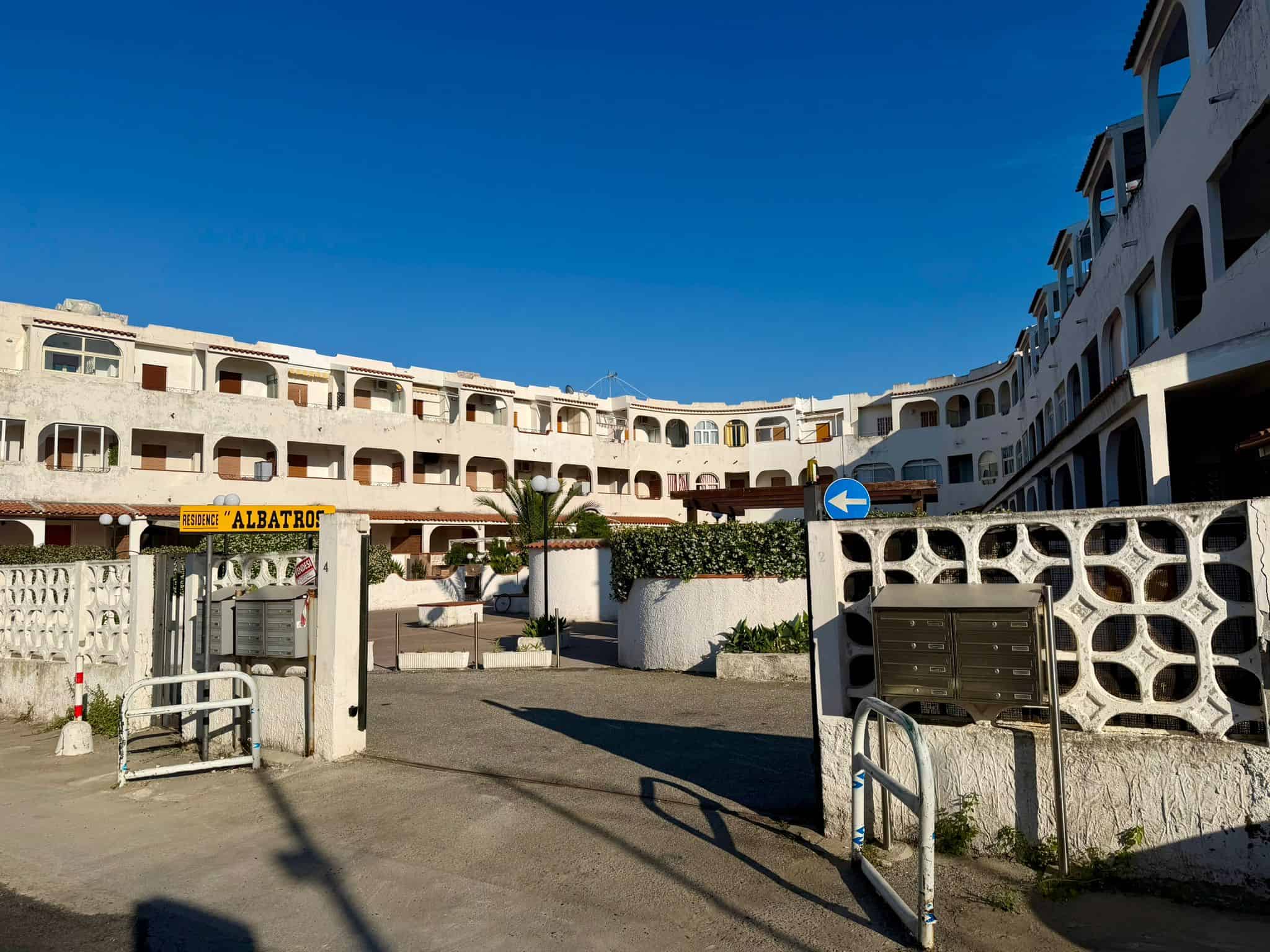 Ampio complesso residenziale con architettura moderna e balconi, situato in una zona soleggiata e ben servita, ideale per chi cerca un appartamento in affitto o in vendita vicino al mare.