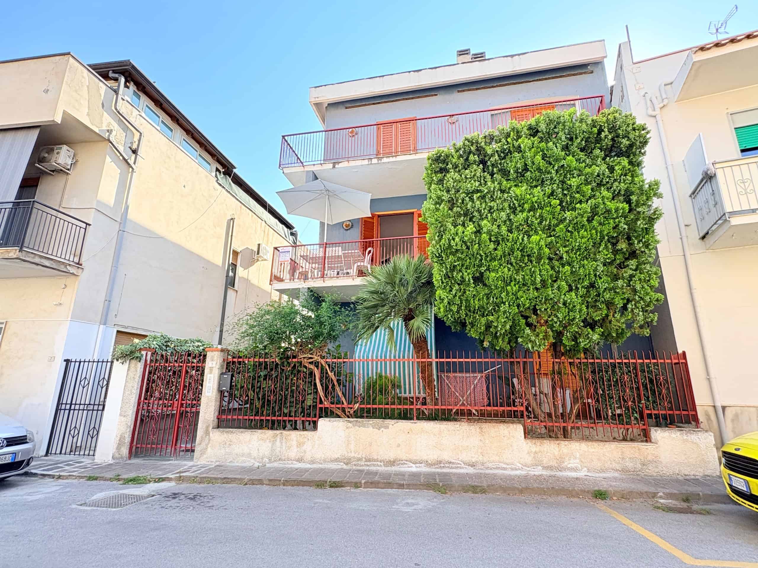 Edificio residenziale con balconi e giardino privato, situato in zona urbana, con facciata moderna e spazi esterni ben curati, ideale per famiglie e investimenti immobiliari.
