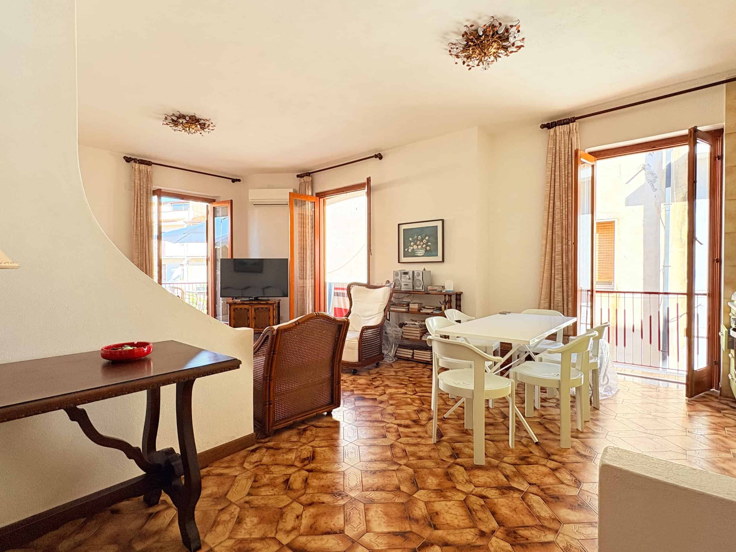 Interno luminoso e accogliente di un appartamento con soggiorno e zona pranzo, con grandi finestre e arredamento confortevole, ideale per vivere in relax a NextCasa.