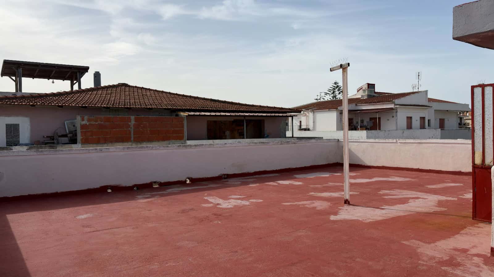 Pannello solare sul tetto di un edificio residenziale con terrazza all'aperto, cielo sereno, in un contesto urbano italiano.
