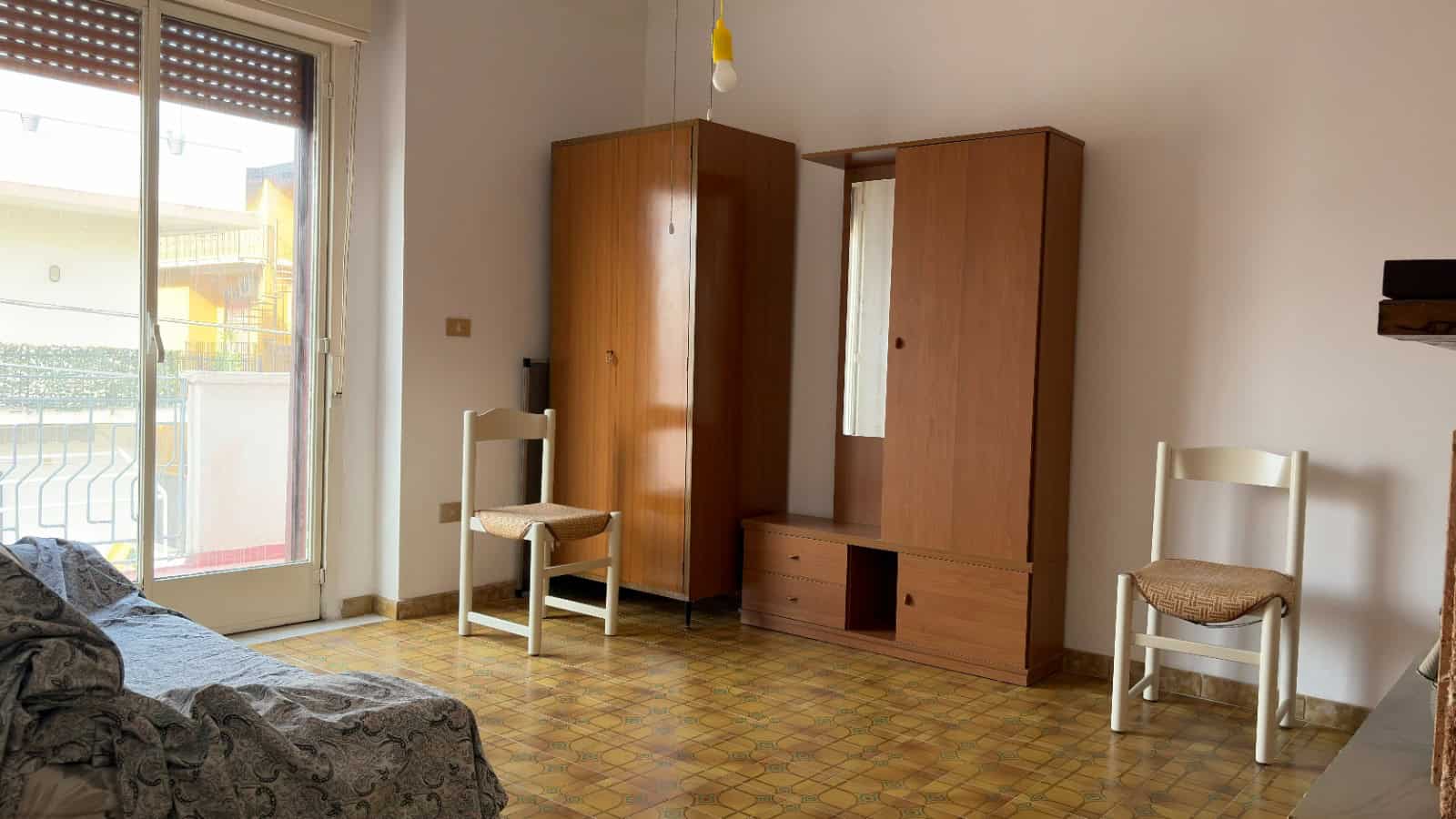 Appartamento con arredi minimalisti e balcone, vista luminosa sulla città, pavimento in parquet, ideale per soggiorni confortevoli e funzionali.