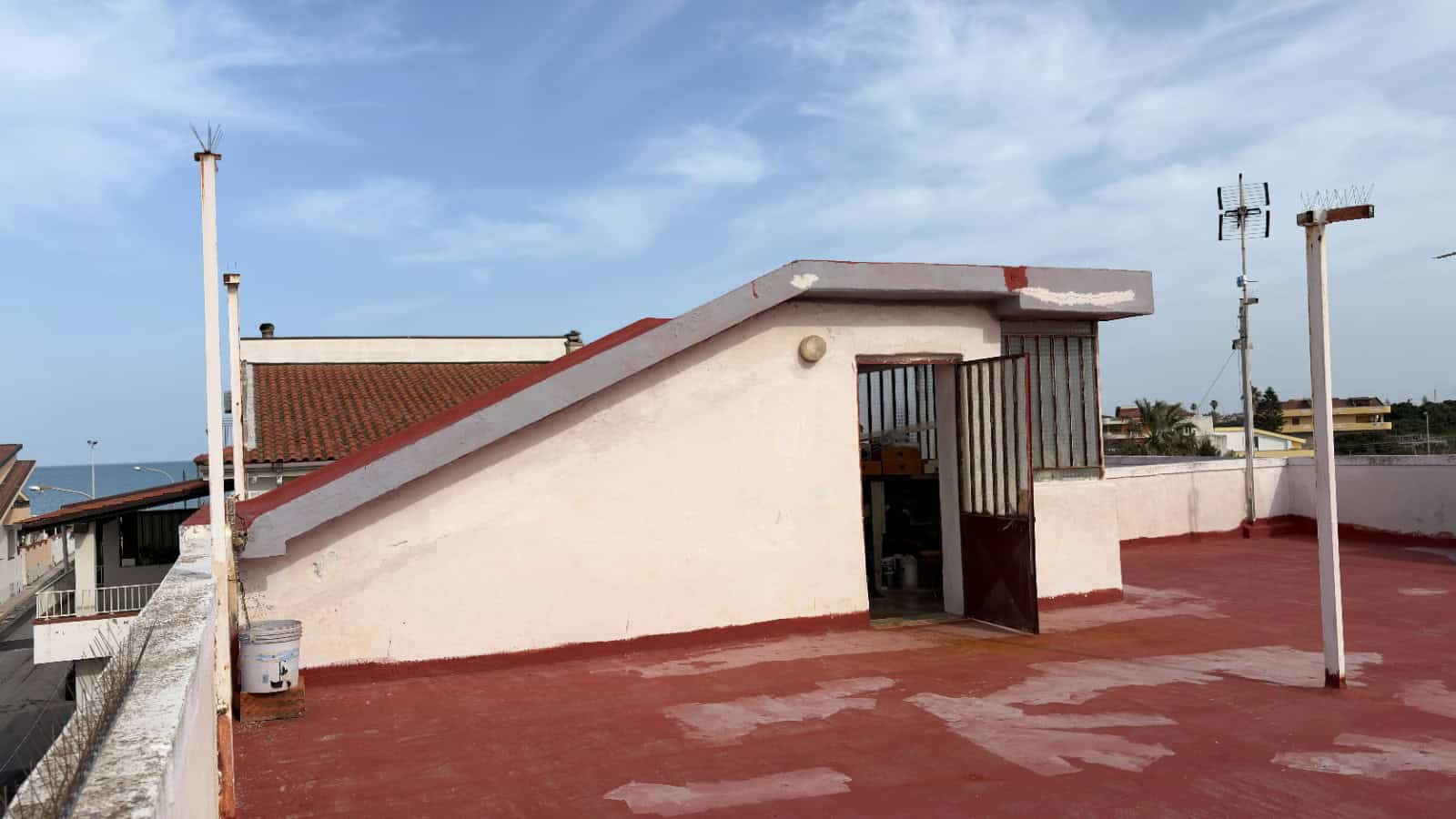 Ilustrativa copertura di un edificio residenziale con terrazza sul tetto, vista panoramica e strutture per l'antenna. Ideale per immobili in vendita o affitto, con attenzione a comfort e funzionalità.