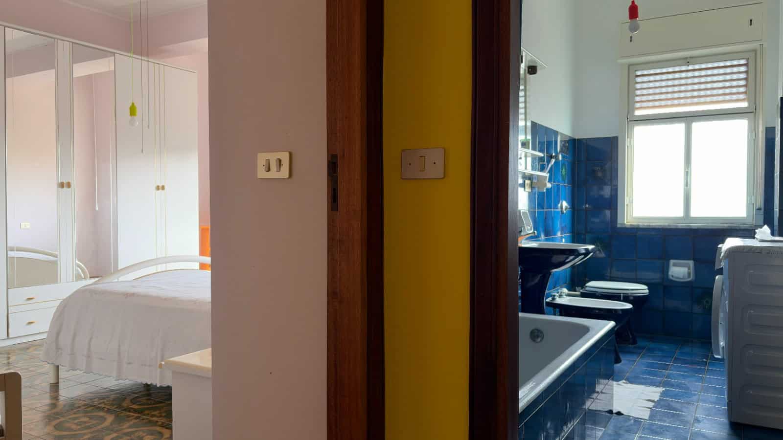 Spazio diviso tra camera da letto e bagno, con arredi funzionali e illuminazione naturale, ideale per ambienti domestici confortevoli e pratici.