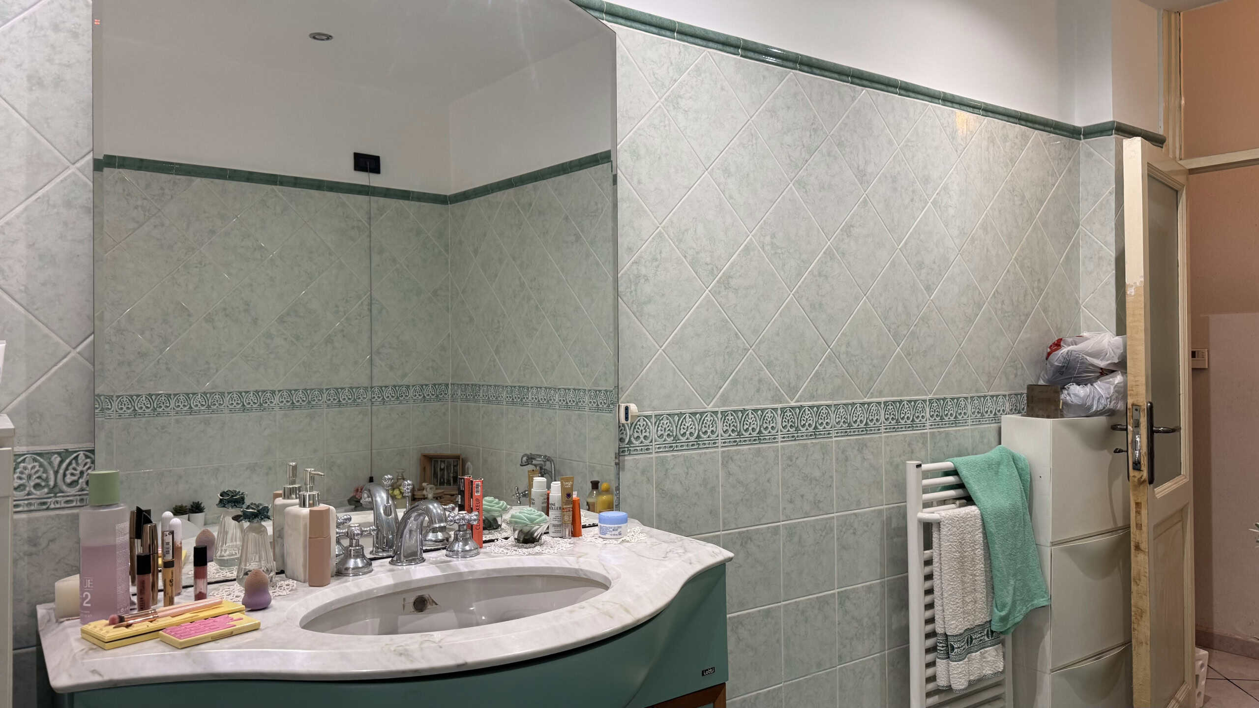 Spazio bagno moderno con lavabo, specchio e accessori per la cura personale, ambientazione di un bagno elegante e funzionale.