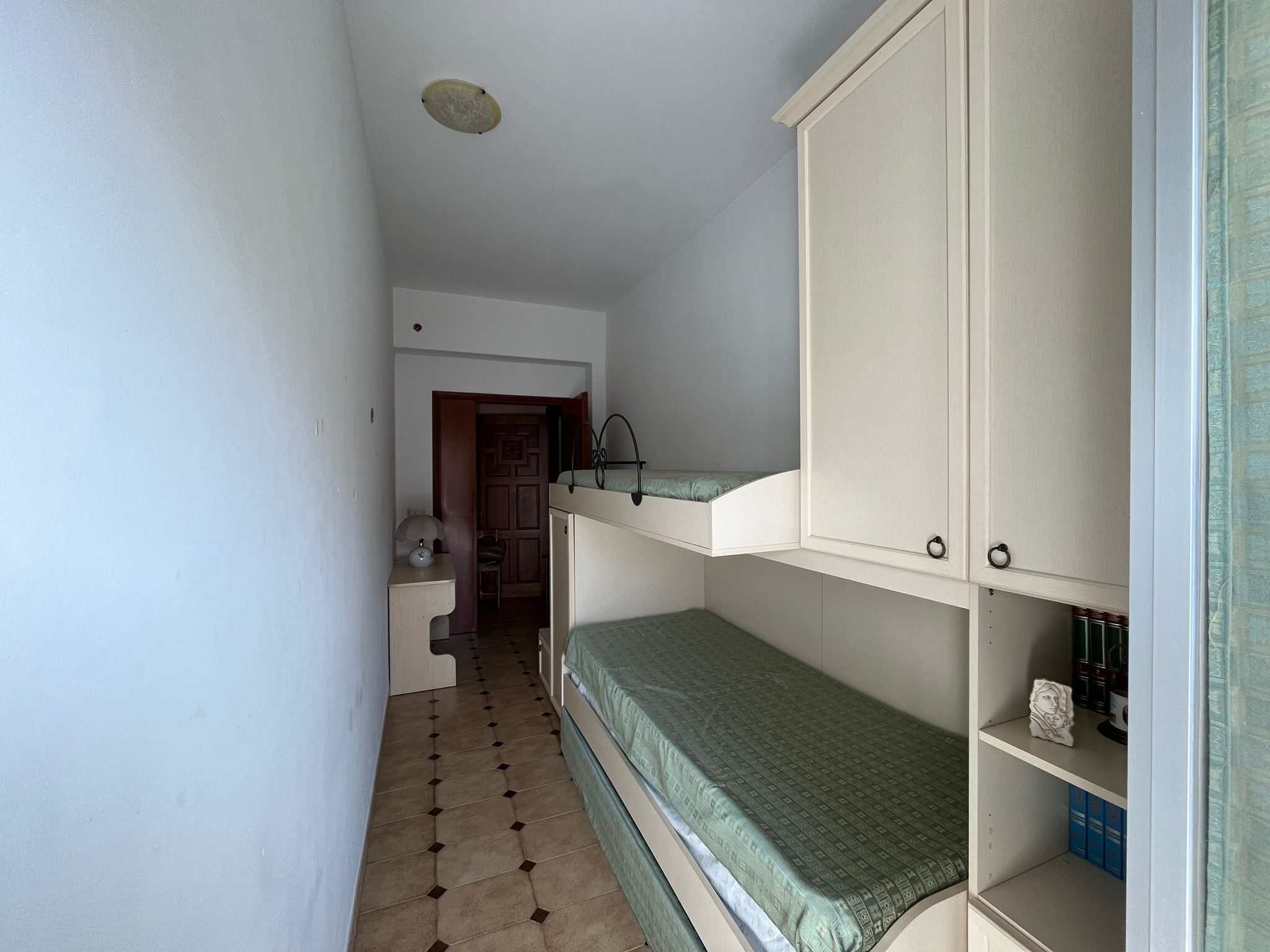 Il testo dell'immagine mostra una cameretta con letto a castello, armadio e scrivania, in un ambiente luminoso e ben organizzato, ideale per studenti o bambini.