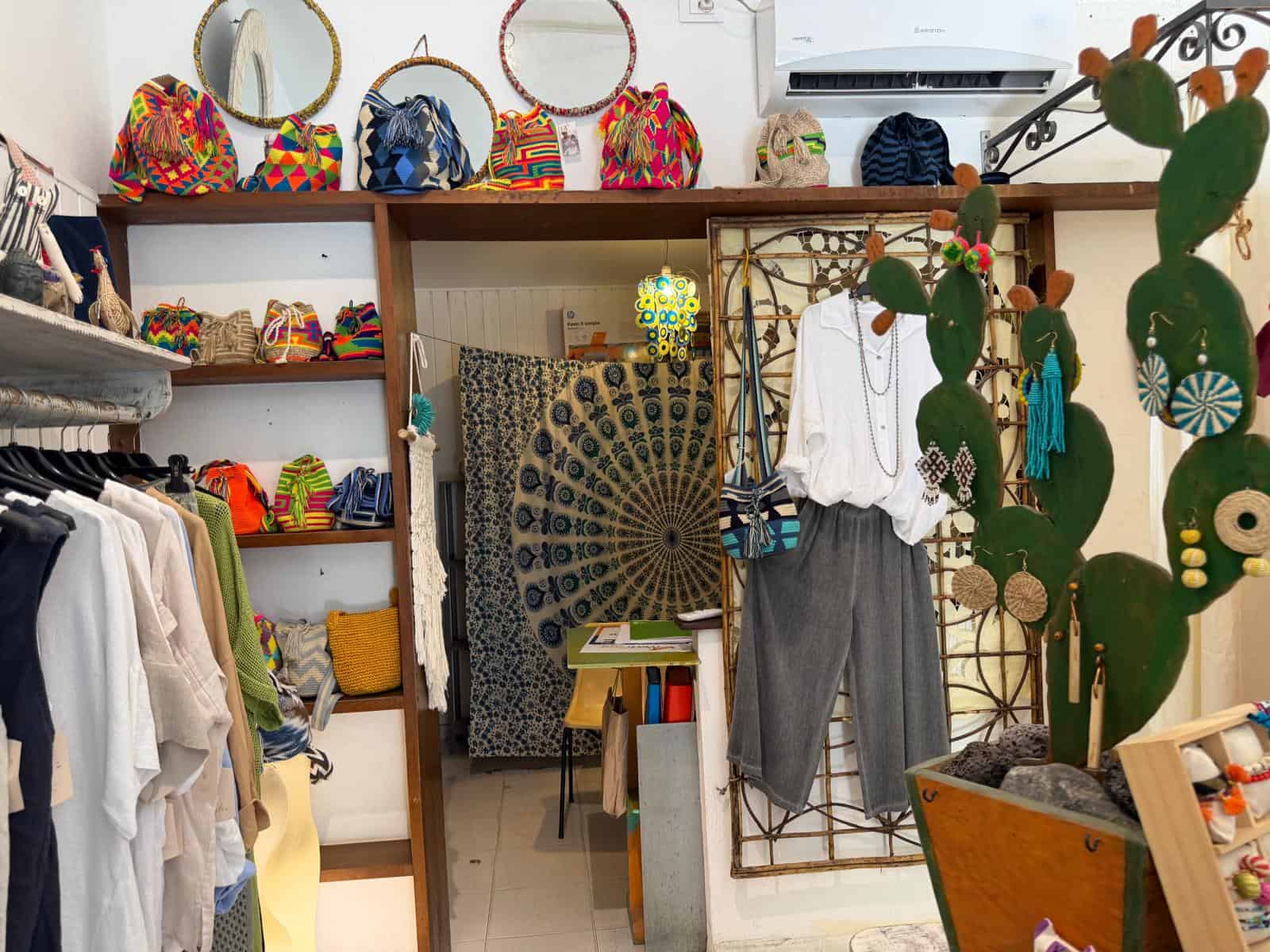 Vetrina di accessori e abbigliamento colorati con borse, vestiti e decorazioni, ideale per negozi di moda e boutique.
