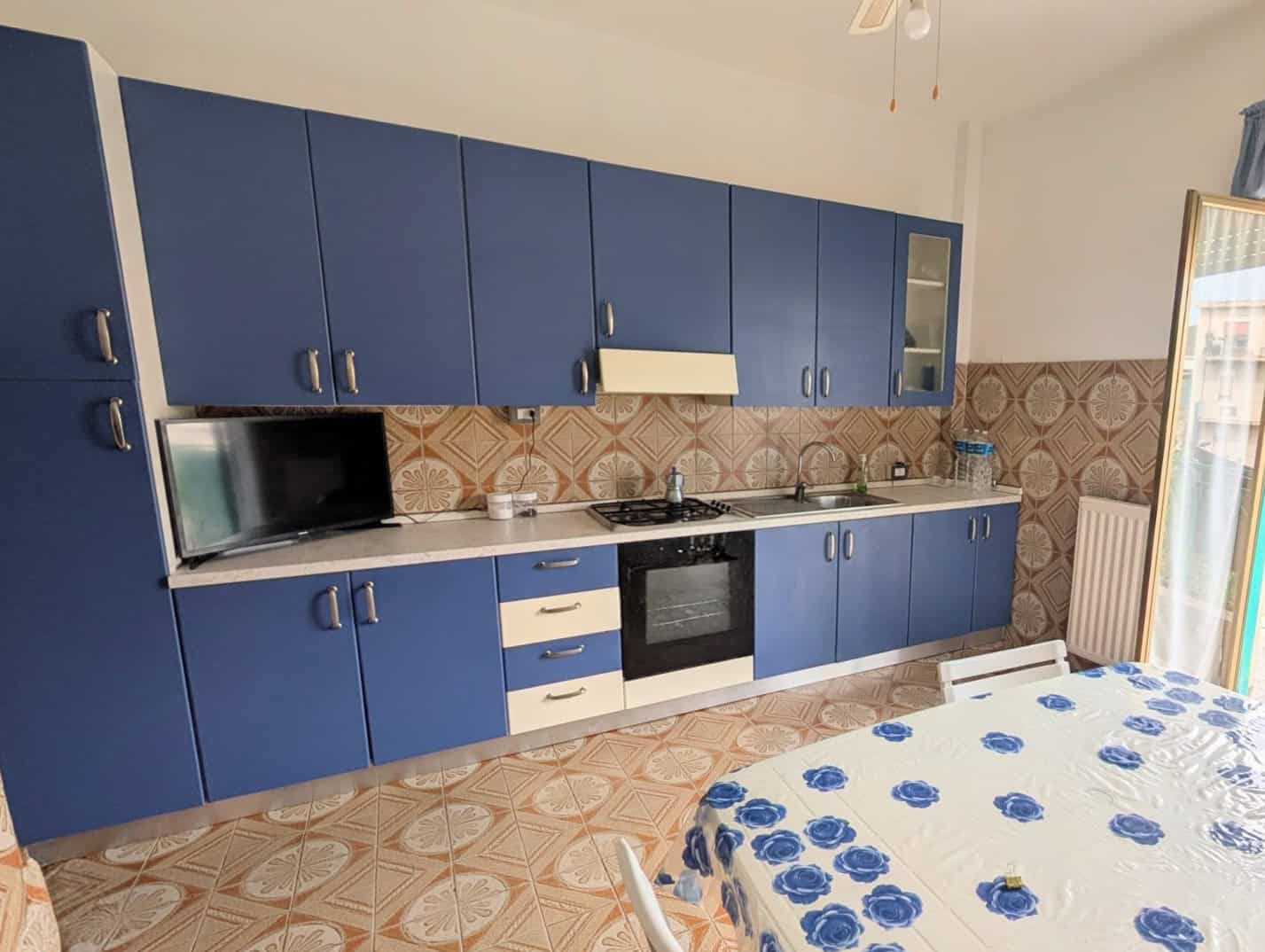 Cucina moderna con ante blu e piano in marmo, ideale per appartamenti di design.