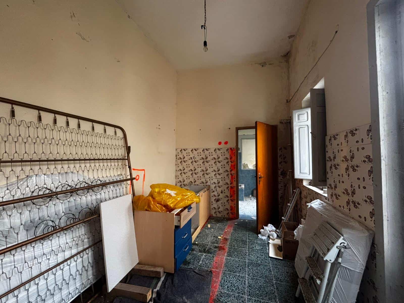 Interno di una stanza abbandonata con mobili vecchi e pareti danneggiate, ideale per foto di ristrutturazione o rinnovamento edilizio.