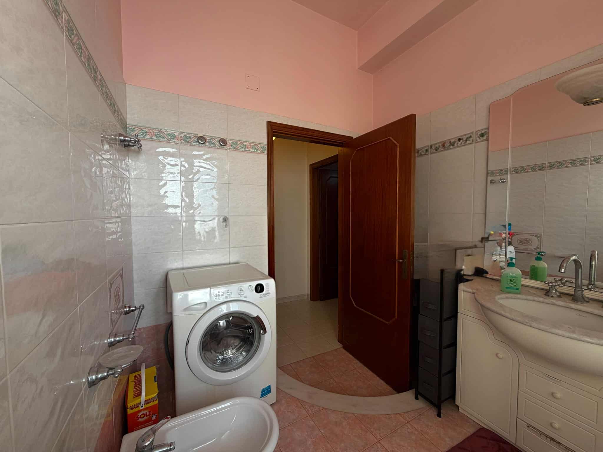 Bagno spazioso con lavatrice, lavabo e specchio, in un appartamento in vendita a Barcellona P.G.