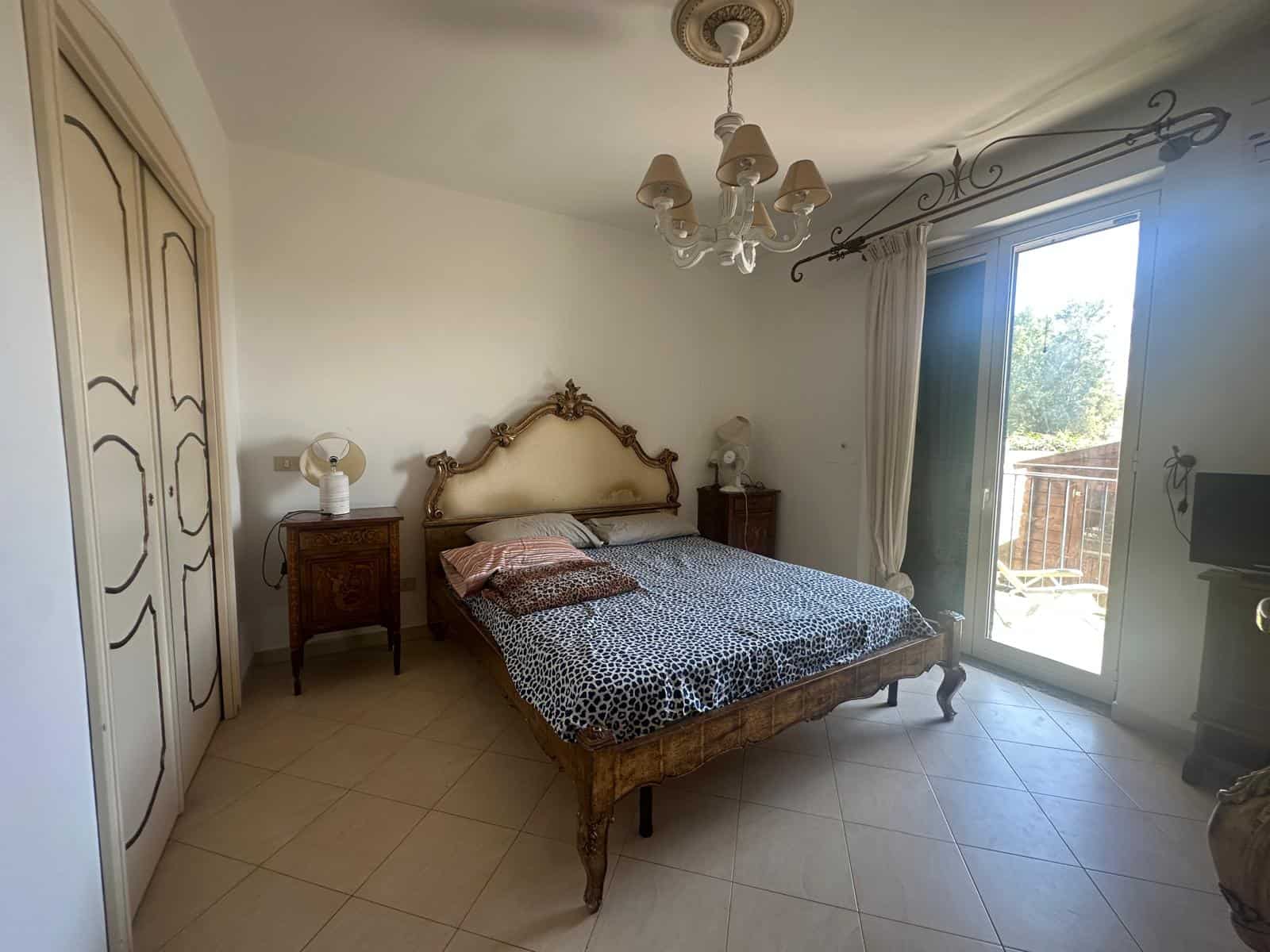 Camera da letto spaziosa con letto in stile classico, armadio grande e accesso a balcone con vista.