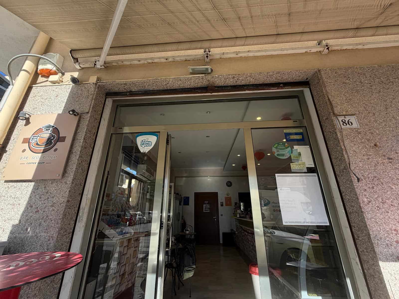 Vetrina di un'attività commerciale in Via Risorgimento 86, Milazzo, con ingresso in vetro e segnaletica esterna.