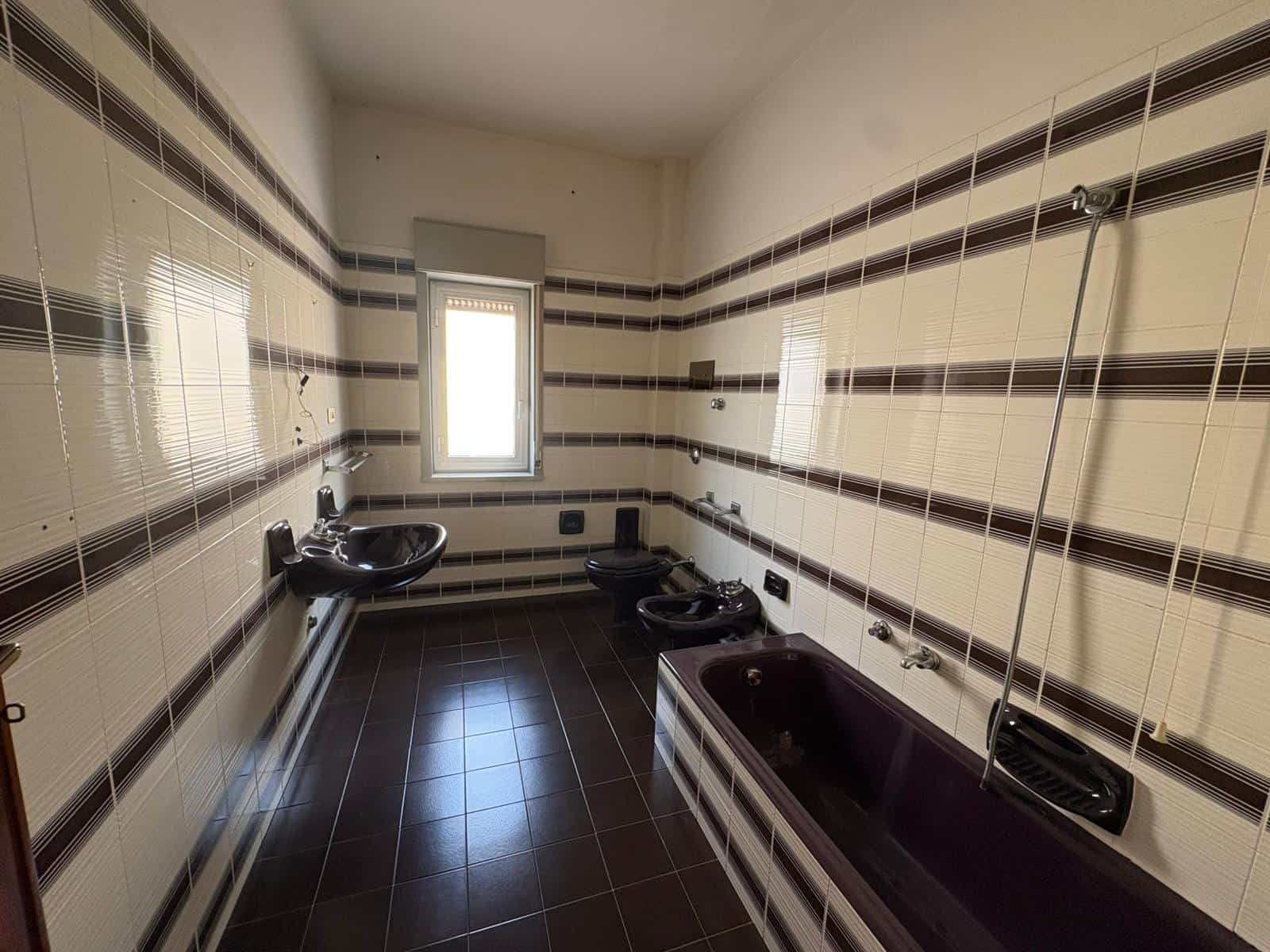 Bagno spazioso con vasca, bidet e lavabo in un appartamento in vendita a Merì, Sicilia.