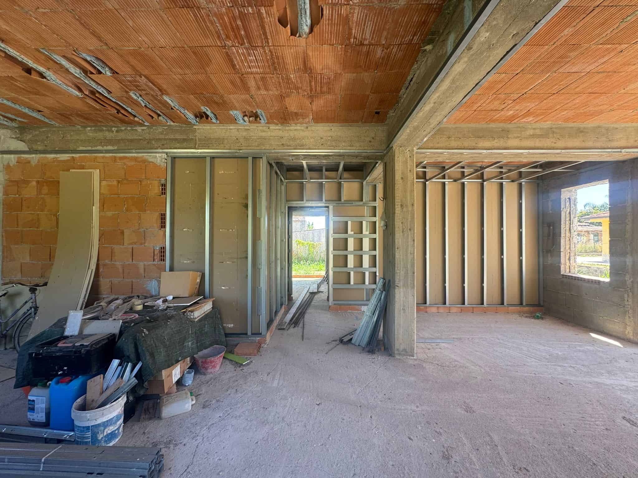 Interno di un edificio in costruzione con strutture in cemento e pareti in mattoni, pronto per finiture.