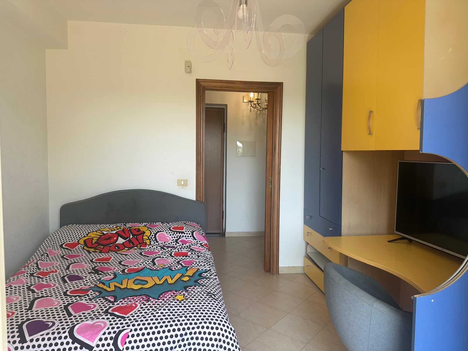 Camera da letto in appartamento in vendita a Milazzo con arredi moderni e colori vivaci.