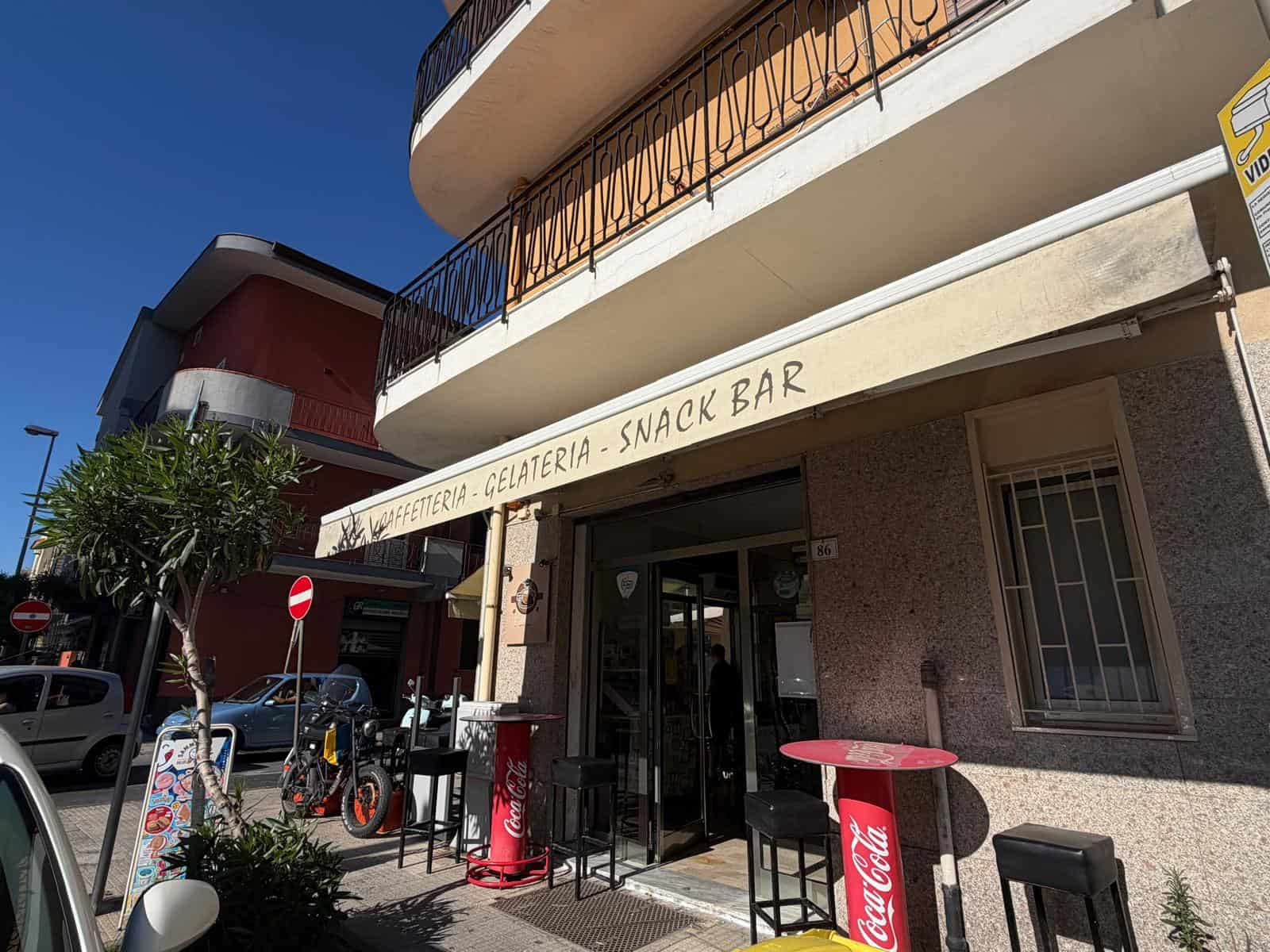 Esterno di una gelateria e snack bar in Via Risorgimento 86, Milazzo, con sedie e tavoli all'aperto.