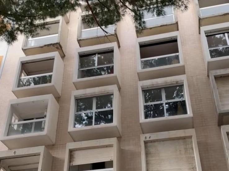 Balcone di un appartamento moderno con grandi finestre e vista sulla città, in un edificio residenziale di alta qualità, ideale per investimenti immobiliari e affitti a breve termine.