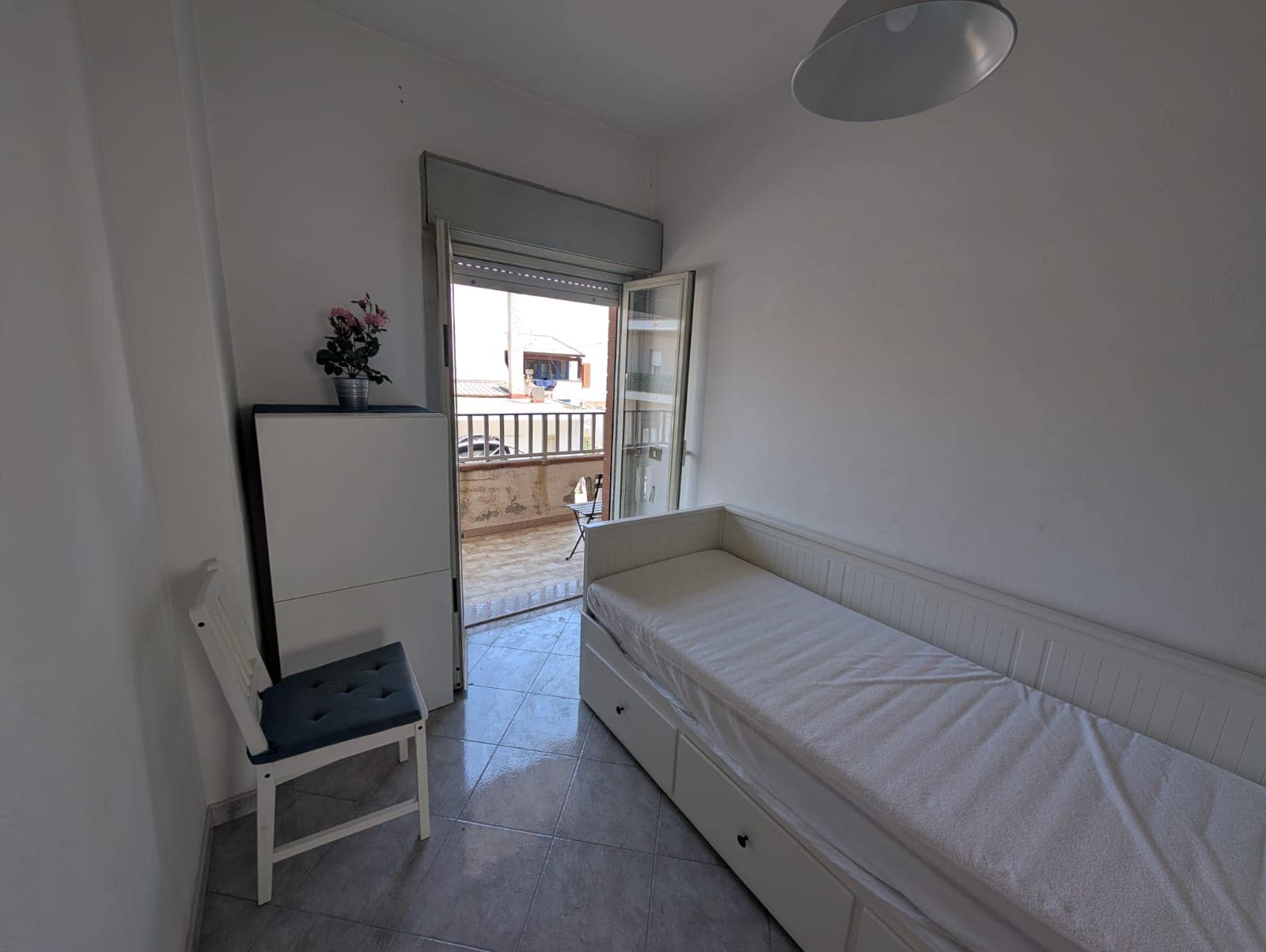 Camere da letto luminose con balcone e vista mare, arredate con letto singolo e armadio, ideali per soggiorni confortevoli.